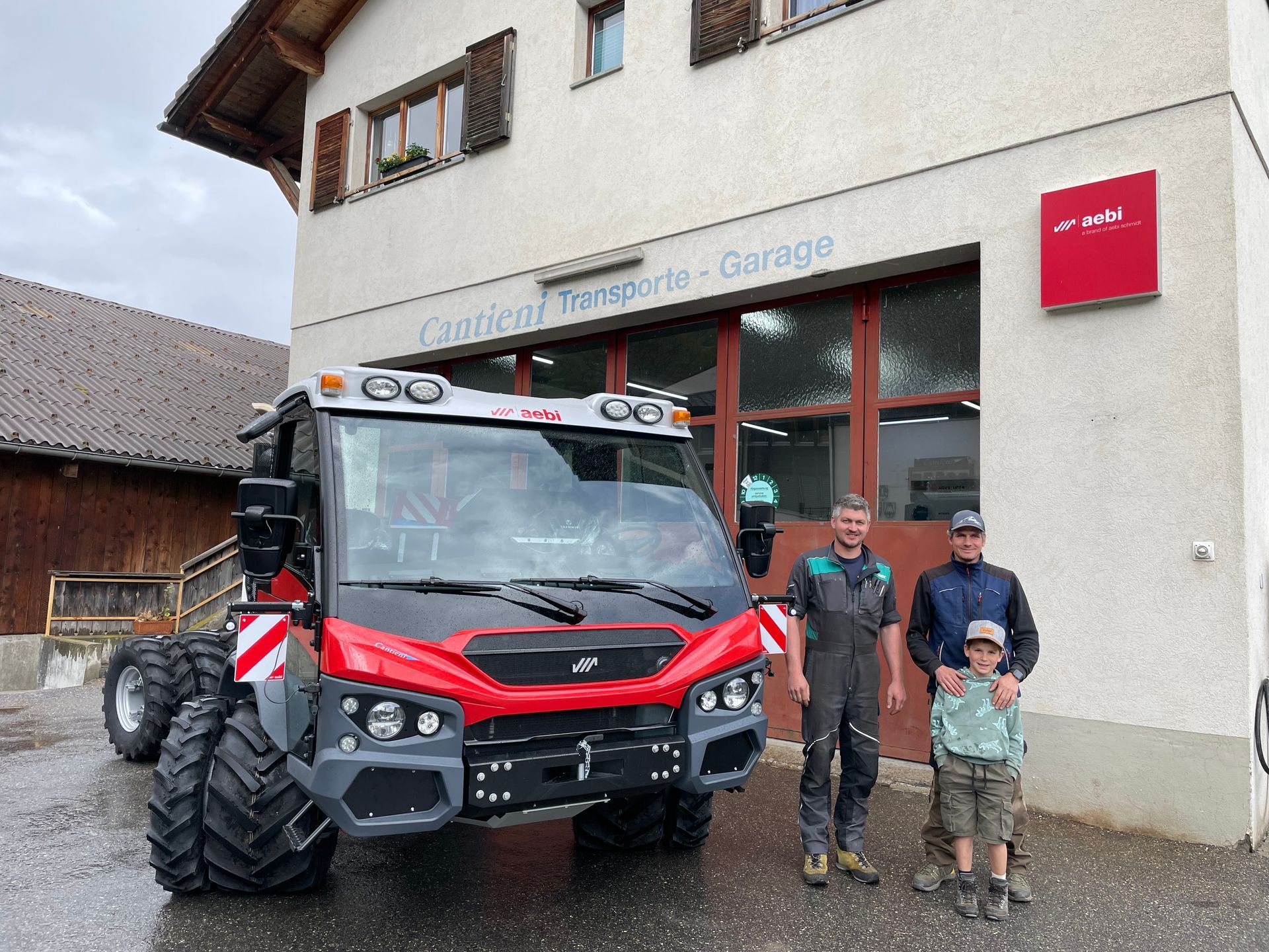 Eine Gruppe von Menschen steht vor einem Lastwagen.