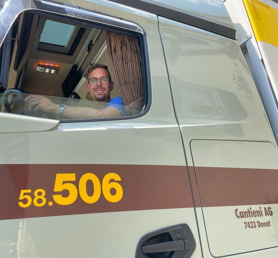 Ein Mann sitzt auf dem Fahrersitz eines LKW mit der Nummer 58.506 auf der Seite