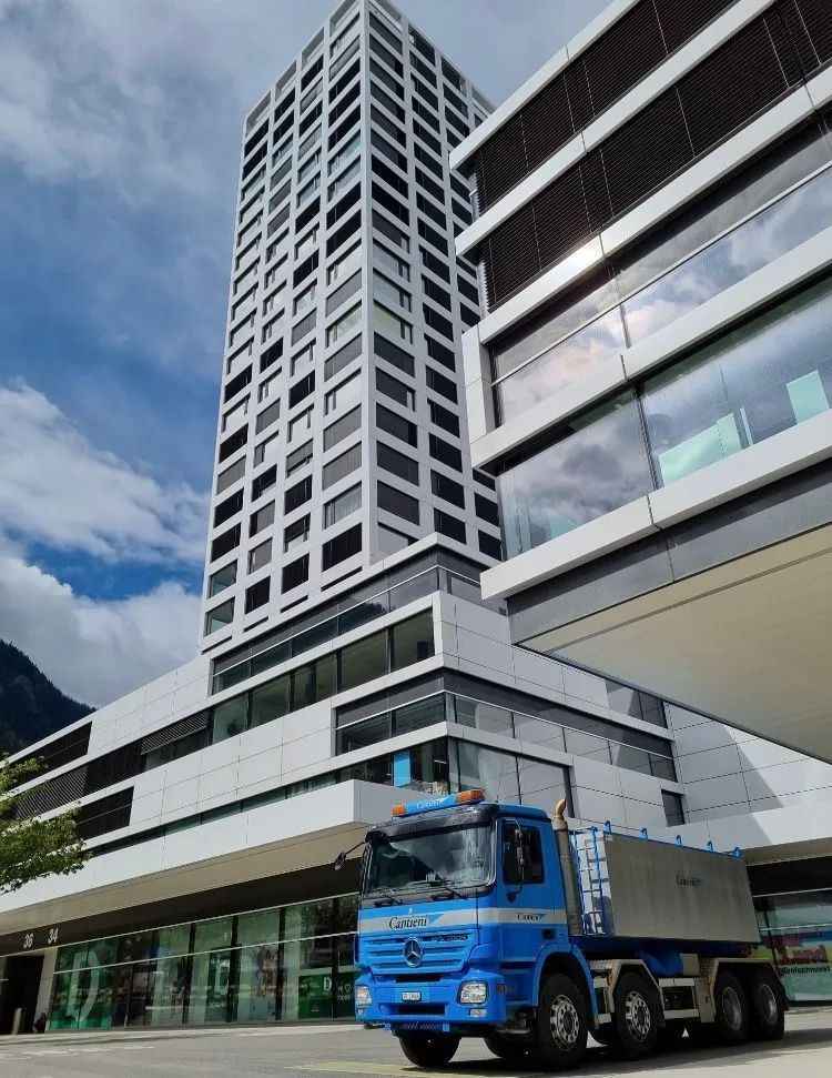 Fahrzeug der Cantieni AG Transporte und Garage vor modernem Gebäude