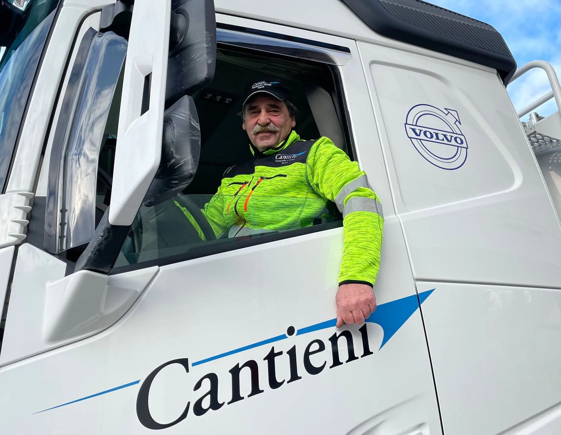 Ein Mann sitzt auf dem Fahrersitz eines Großraum-LKWs.