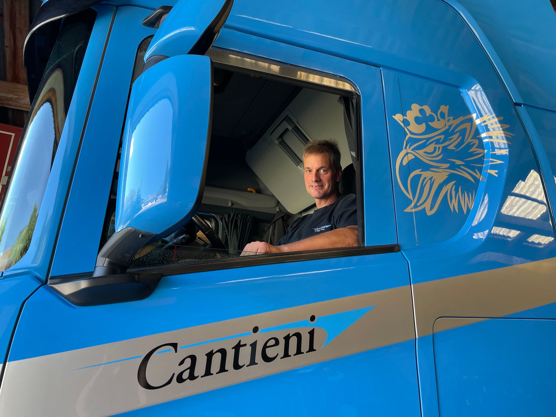 Auf dem Fahrersitz eines blauen Cantieni-Trucks sitzt ein Mann.