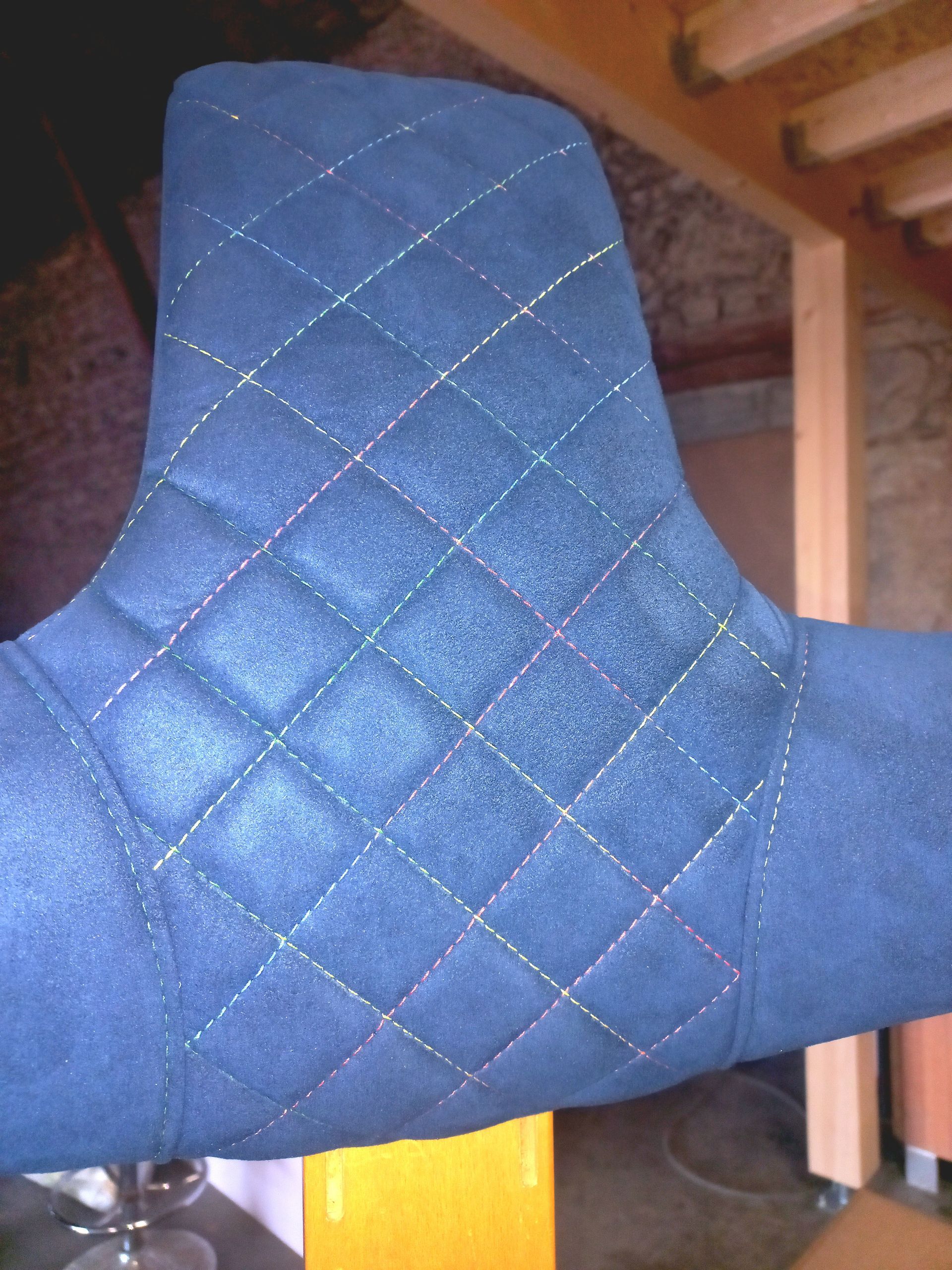 Dossier de chaise matelassé bleu dans une pièce en bois