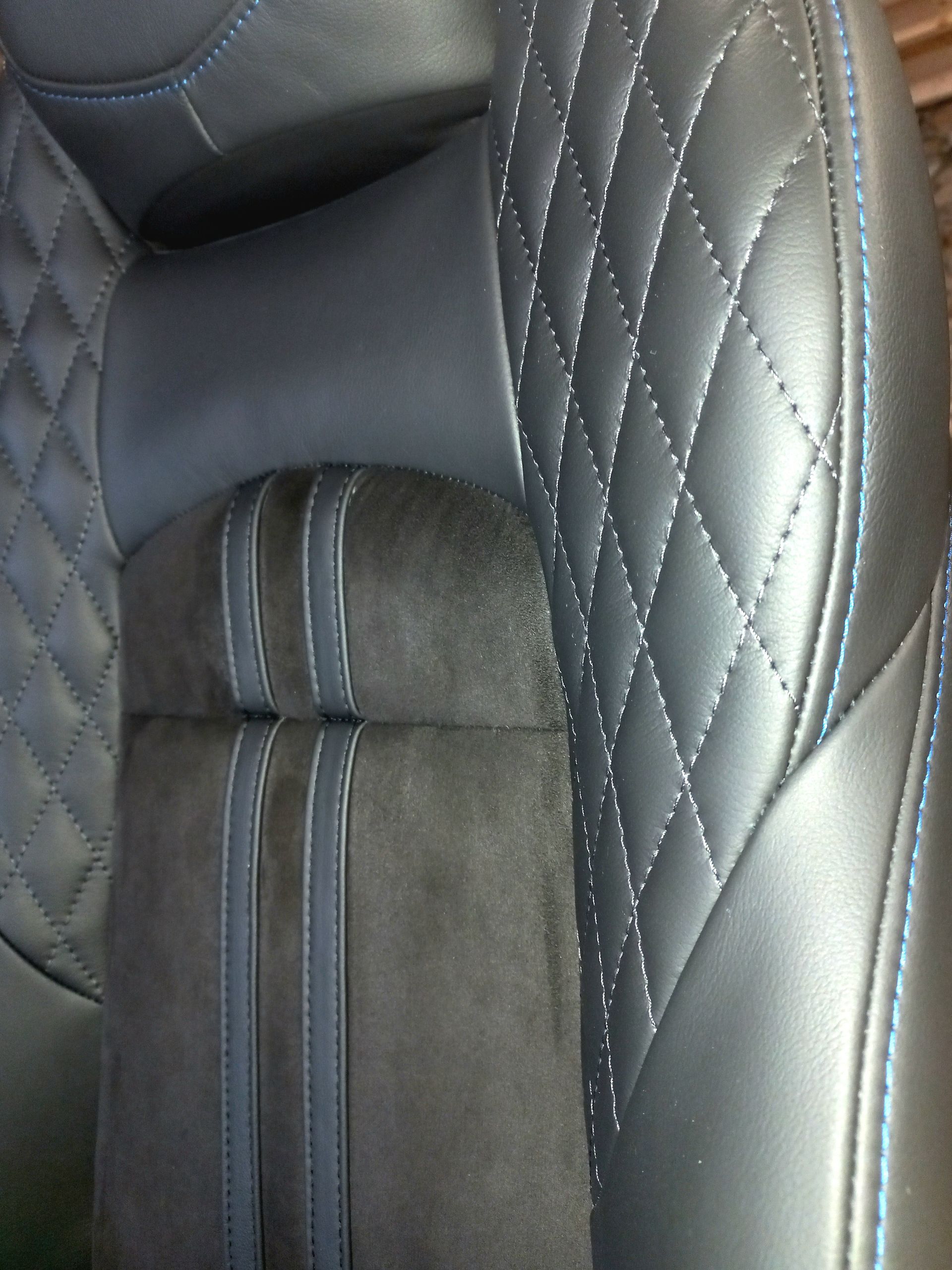Siège auto en cuir matelassé noir avec insert central gris et surpiqûres blanches