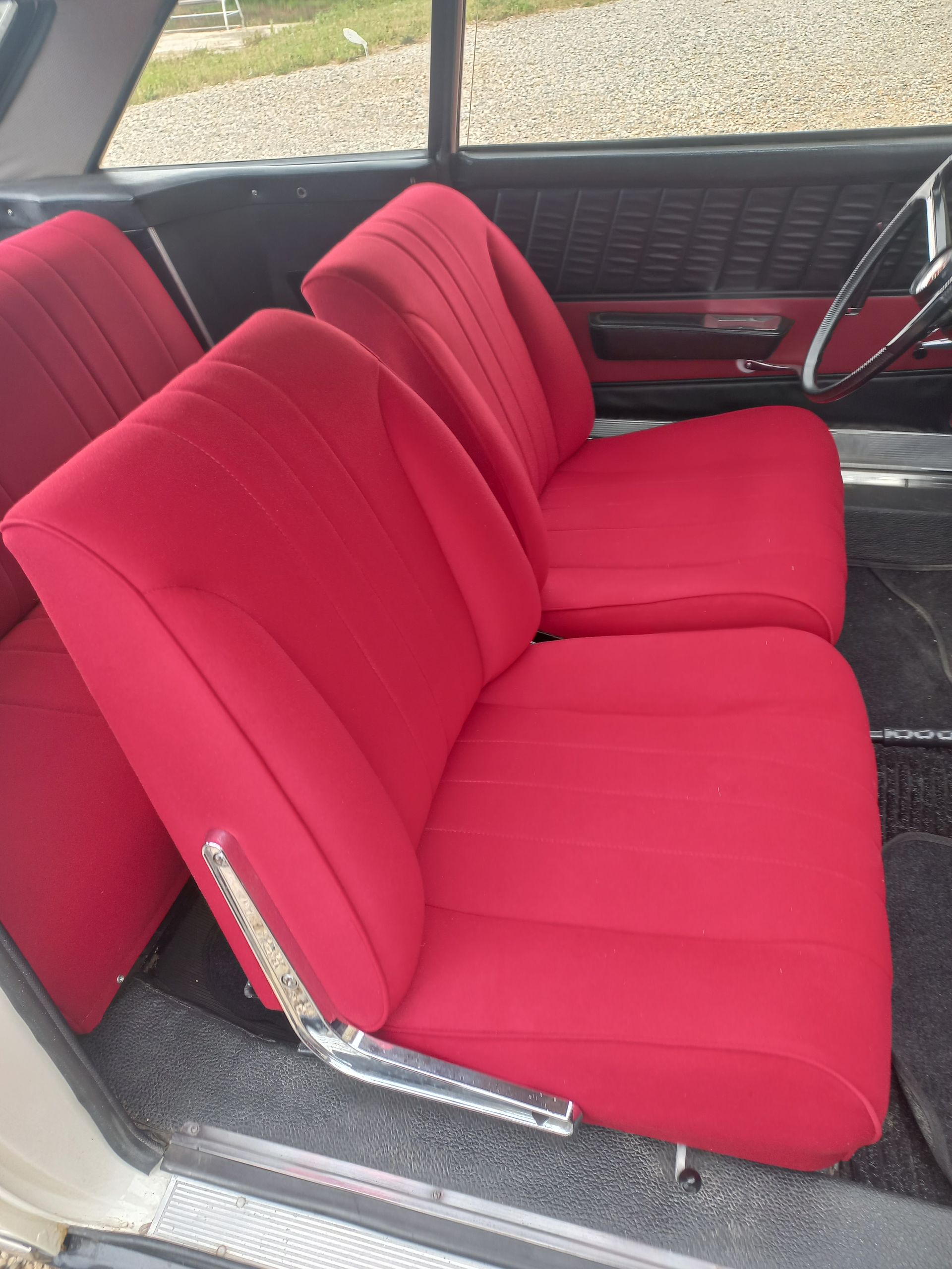 Banquette rouge à l'intérieur d'une voiture, recouverte d'un tissu rose vif.