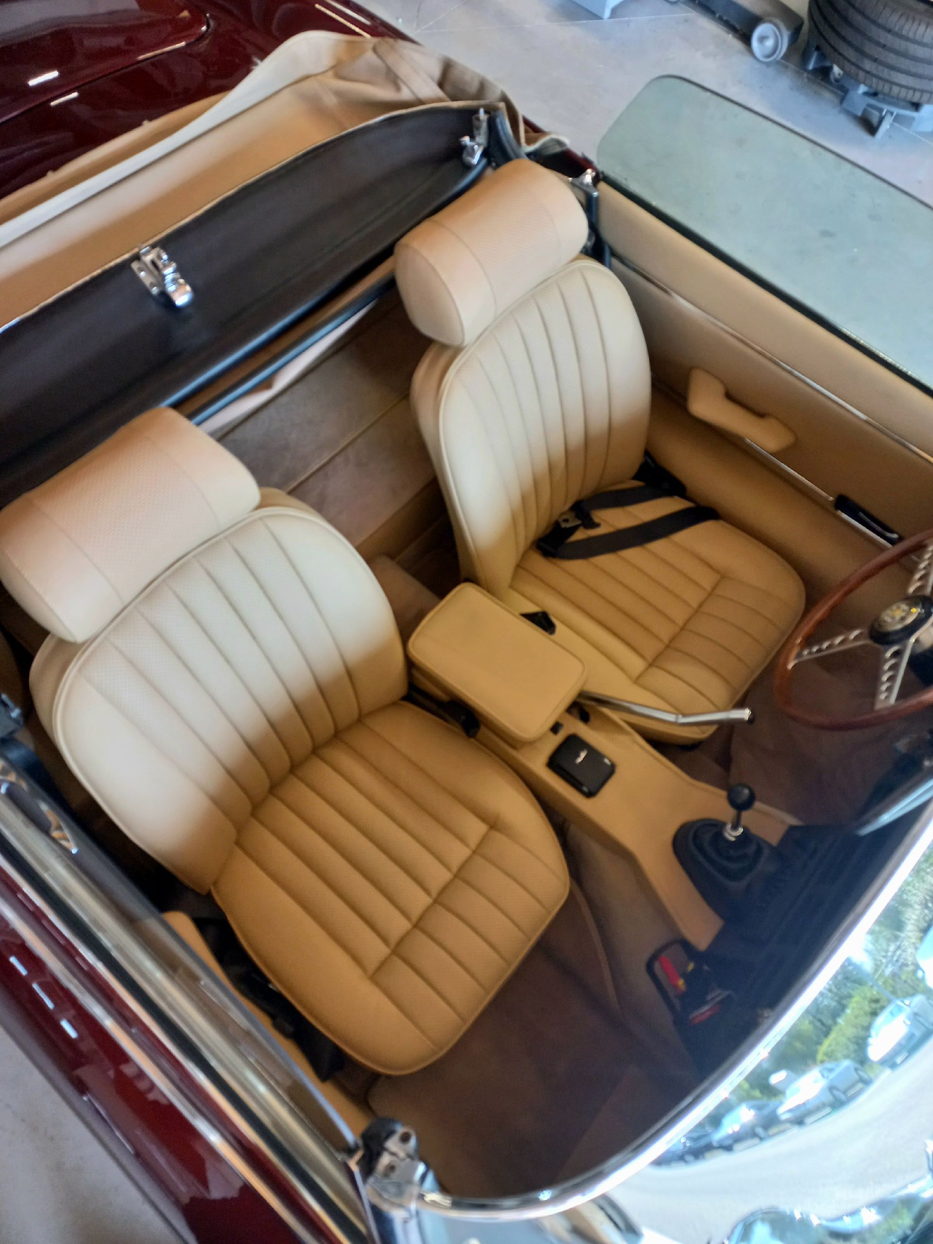 Sièges en cuir crème et intérieur beige vus de dessus dans un cabriolet classique.