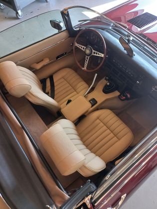 Intérieur de voiture en cuir marron avec sièges avant et tableau de bord visibles, vu depuis la porte ouverte