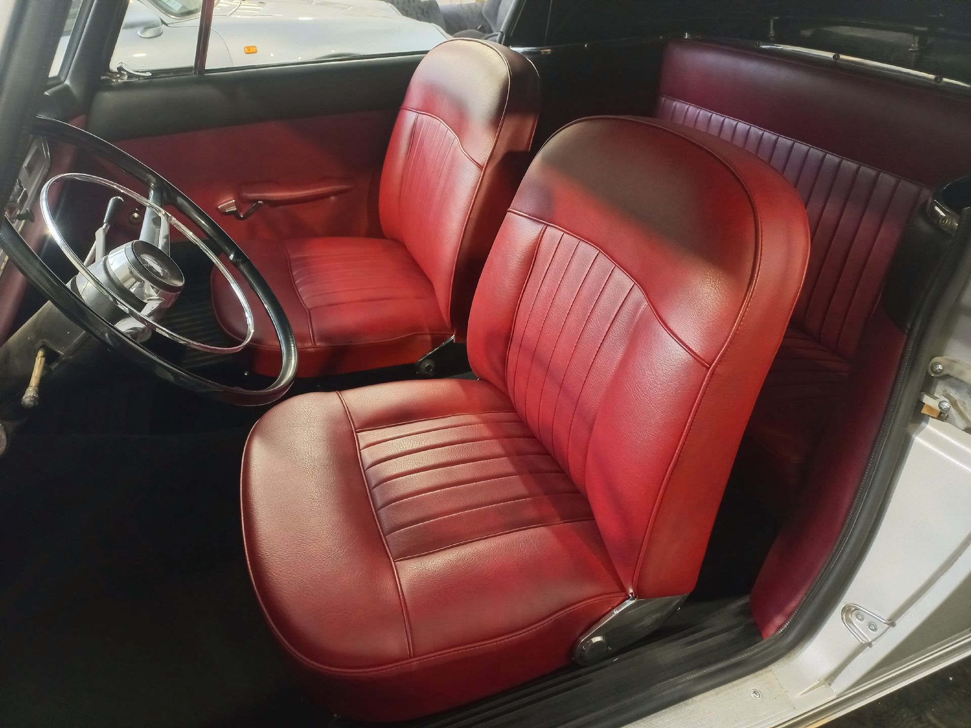 Intérieur de voiture classique avec sièges avant en cuir rouge et volant noir