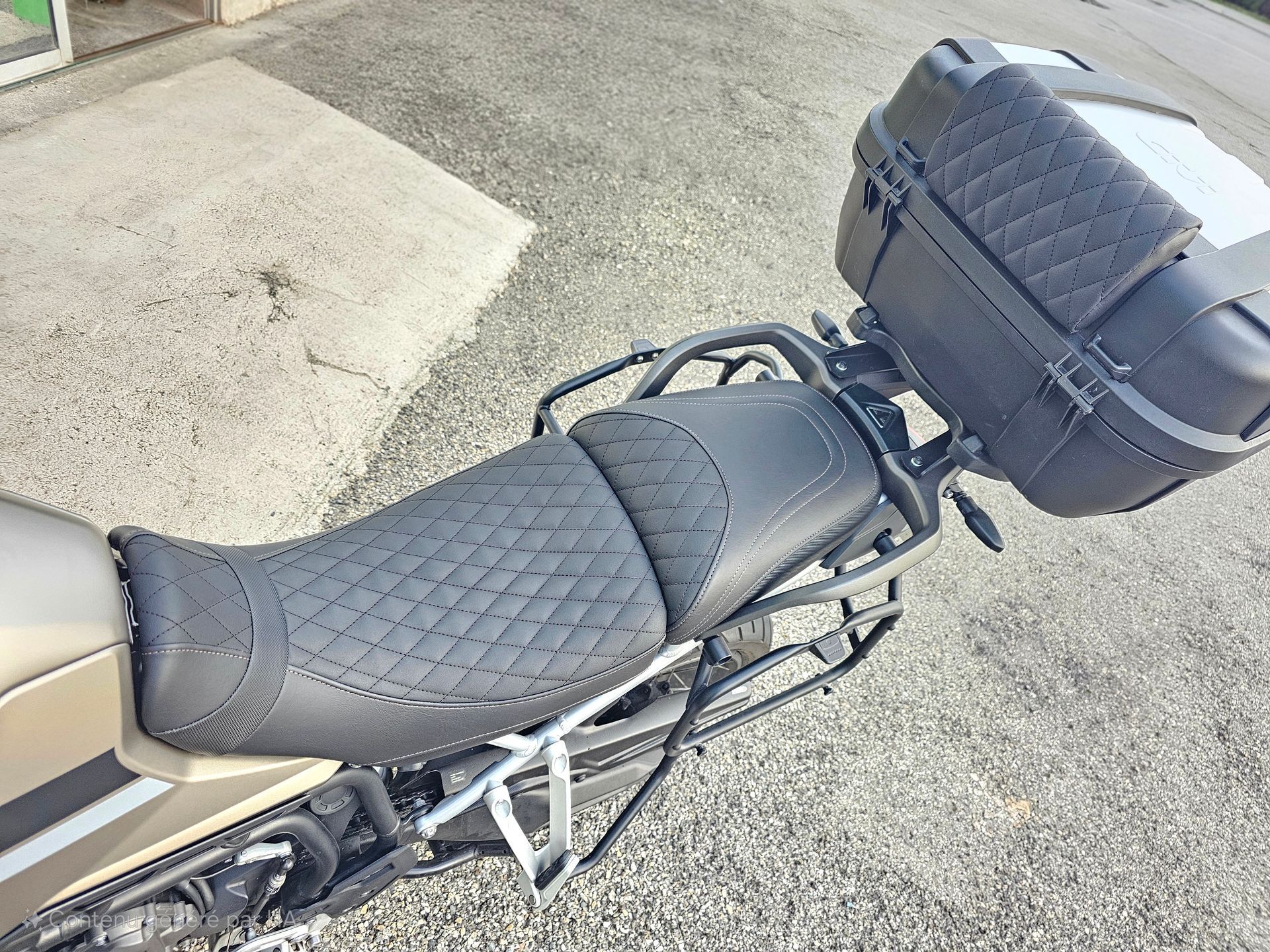 Selle de moto avec revêtement matelassé noir et coffre de rangement arrière, vue de dessus