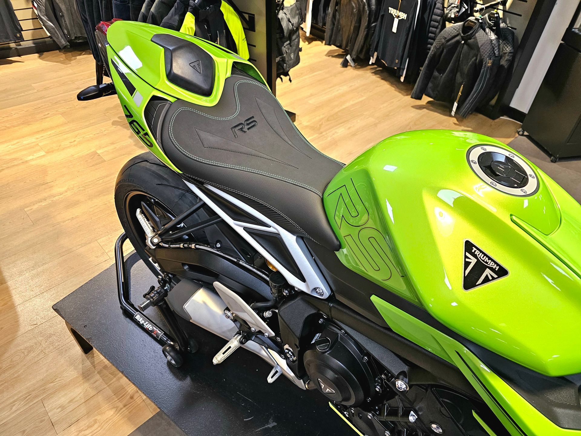 Moto de sport vert vif exposée dans un magasin, vue de profil.