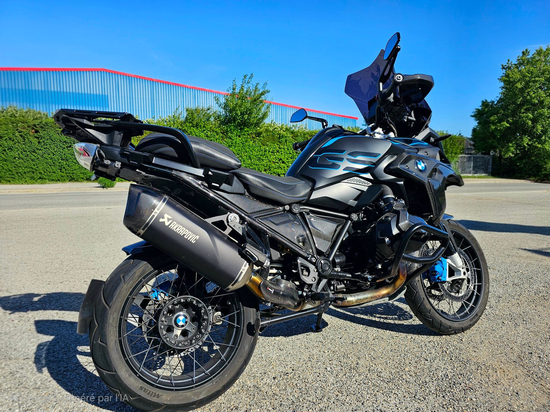 Moto trail noire garée sur une route ensoleillée avec des arbres verts en arrière-plan