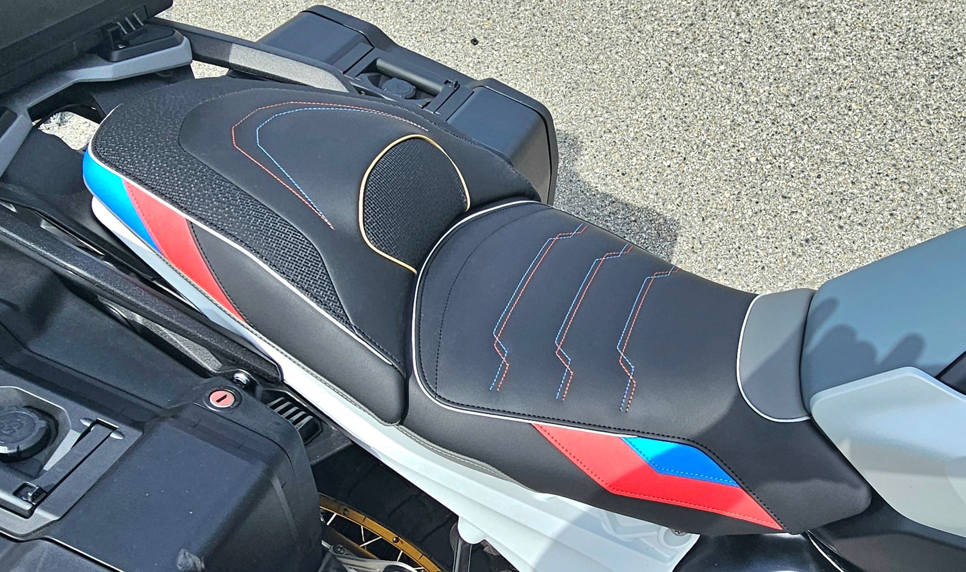 Gros plan sur une selle de moto de sport noire avec des touches de rouge, bleu et blanc