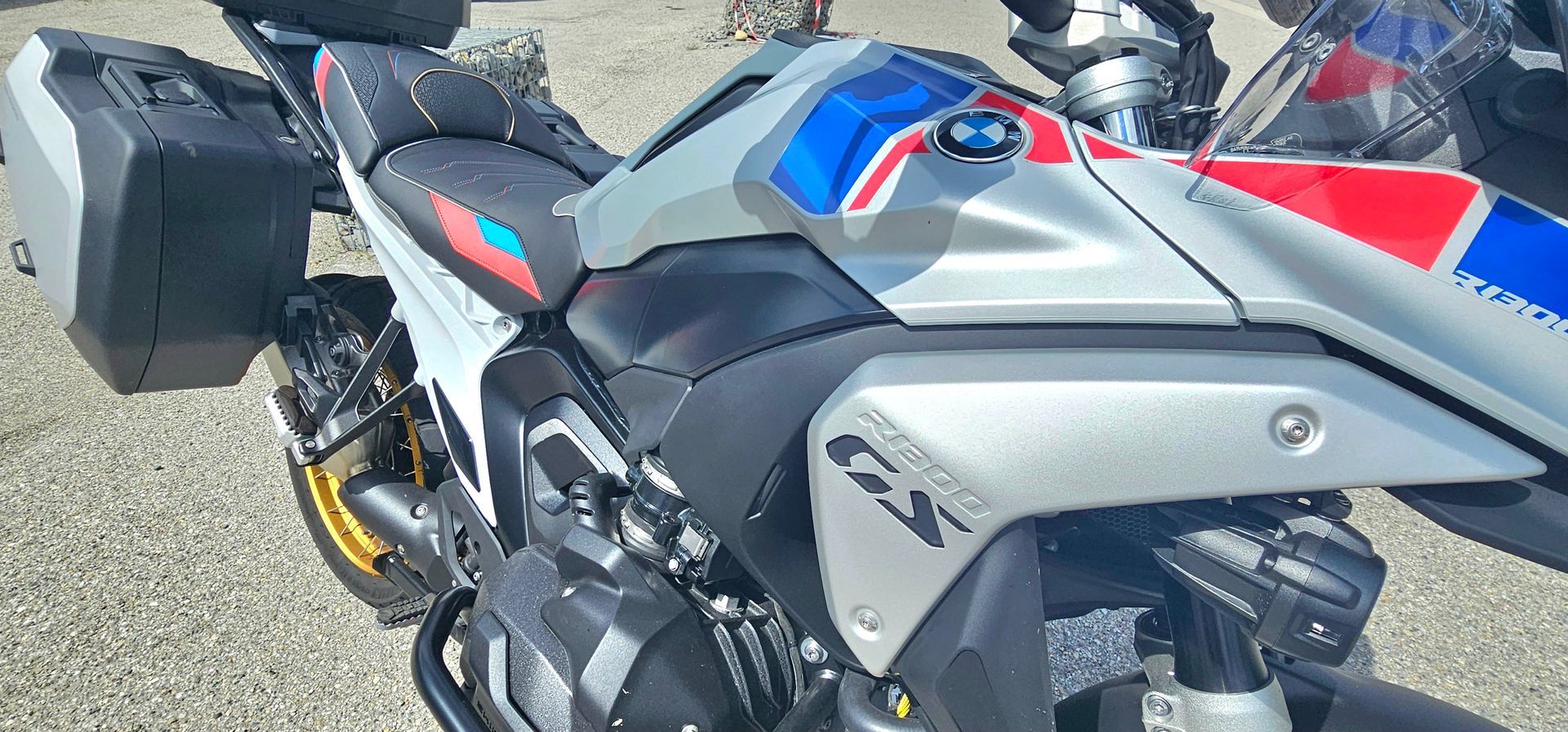 Moto de sport noire et grise avec des touches de rouge, garée à l'extérieur sur le trottoir.