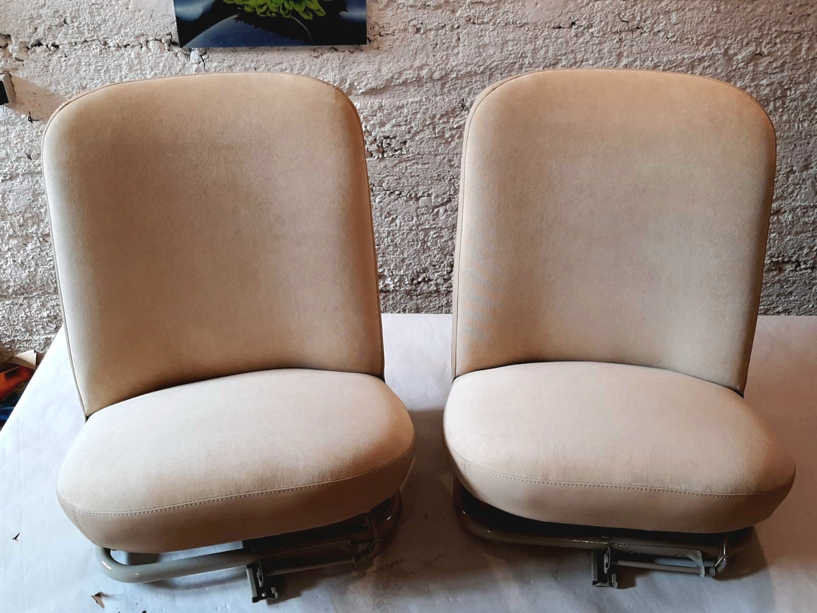 Deux fauteuils beiges à coussins côte à côte sur un sol recouvert de moquette