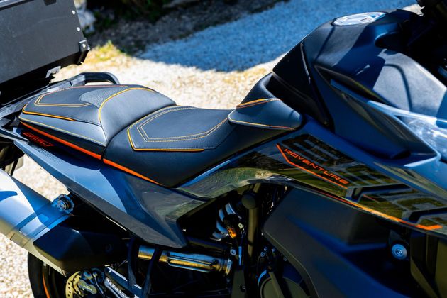 Gros plan sur une moto de sport noire et bleue avec des touches d'orange en plein soleil