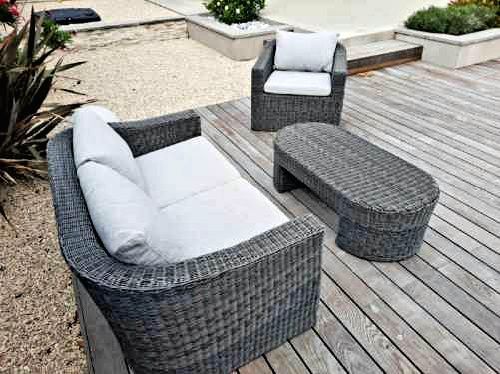 Ensemble de jardin en osier gris avec deux chaises et un pouf assorti sur une terrasse en bois