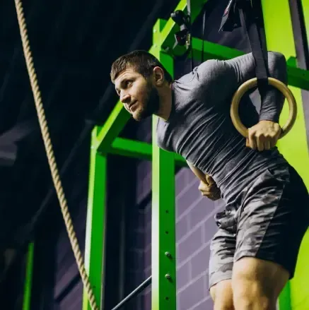 Niña y niño haciendo ejercicio en un gimnasio, con los brazos extendidos