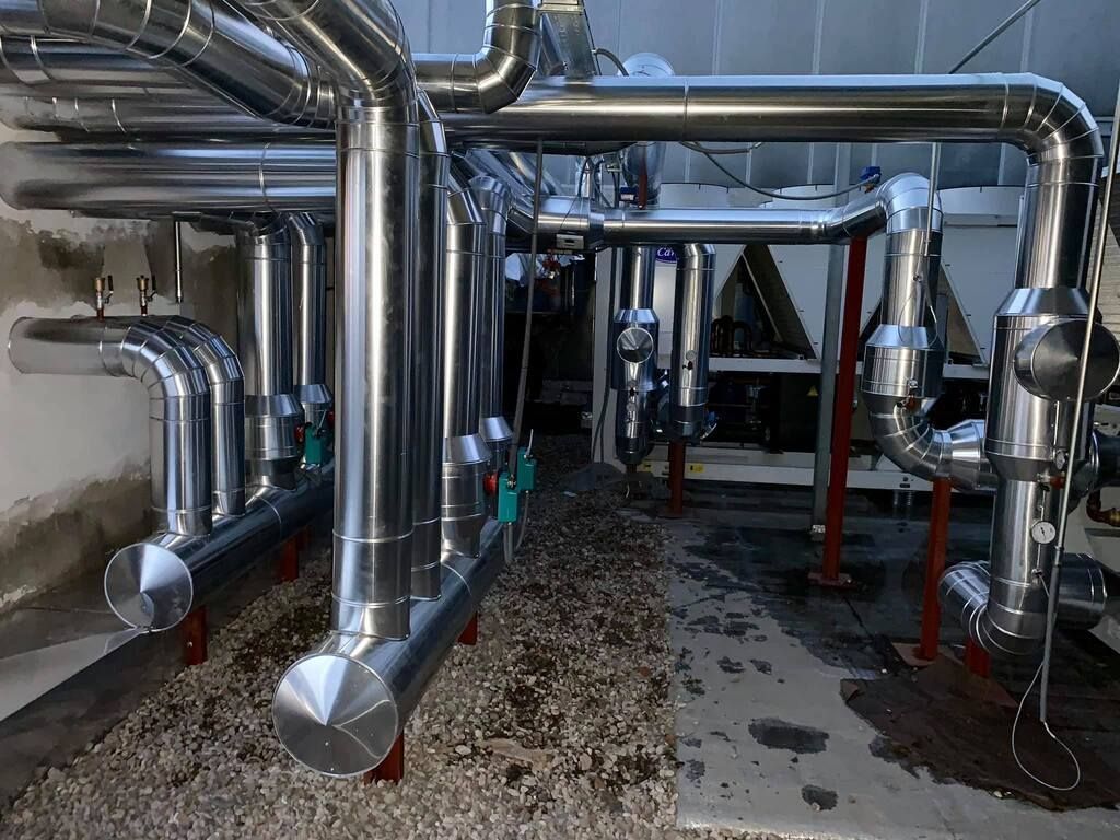 Una fila de tubos de acero inoxidable están alineados en una fábrica.