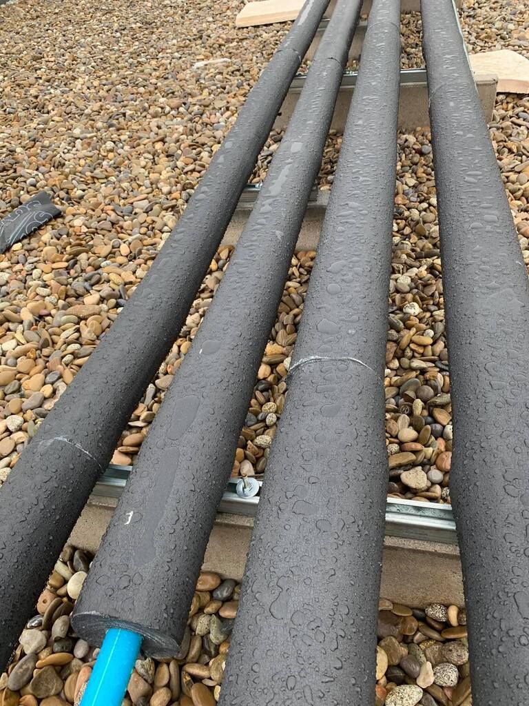 Una hilera de tuberías colocadas encima de una pila de grava.