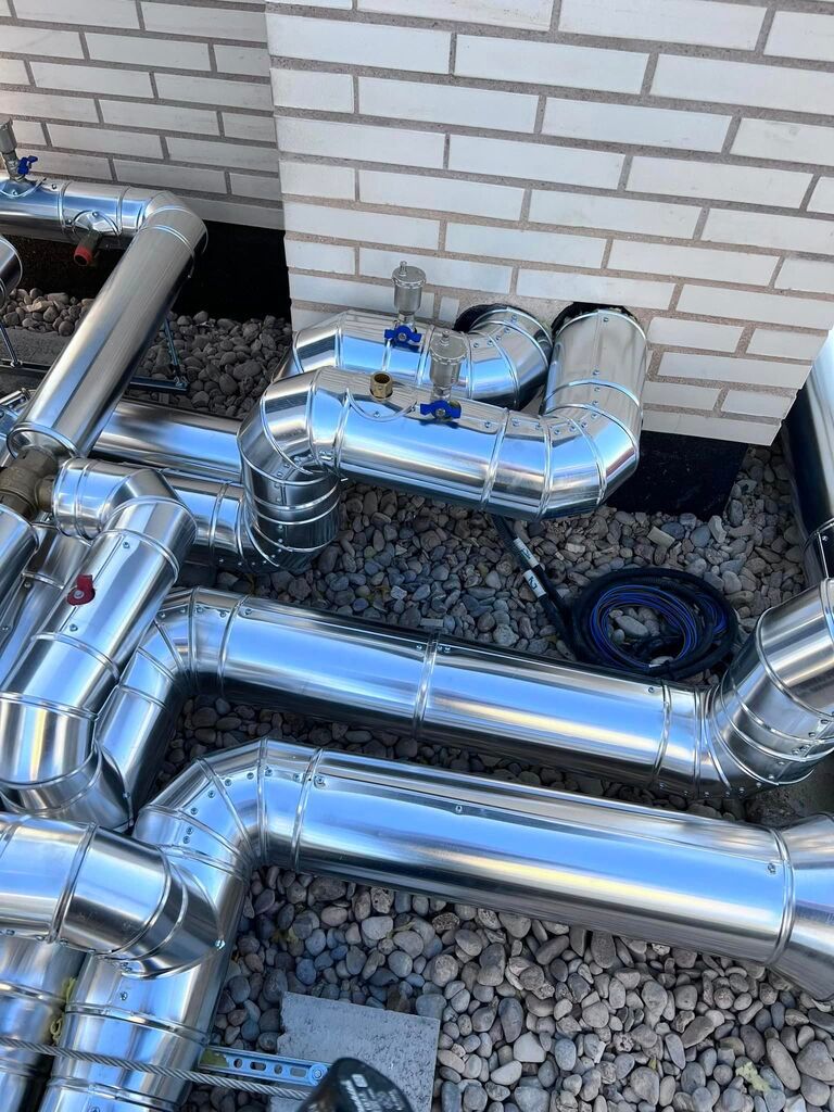 Un montón de tubos de metal están colocados encima de una pila de rocas.