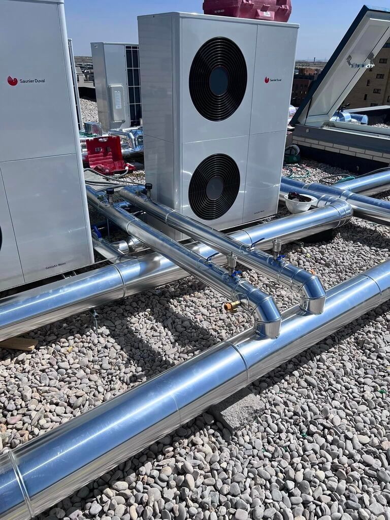 Un par de aparatos de aire acondicionado están encima de una pila de rocas.