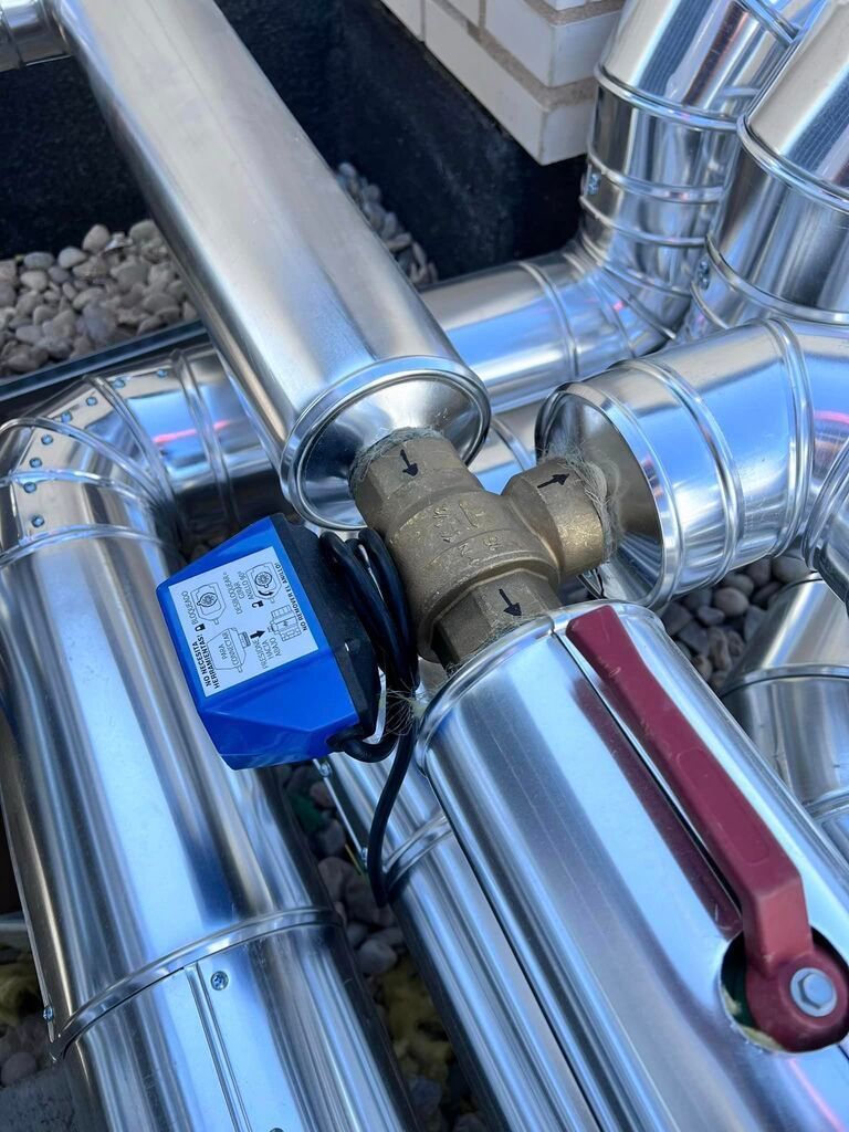 Un primer plano de una válvula en una tubería de metal.