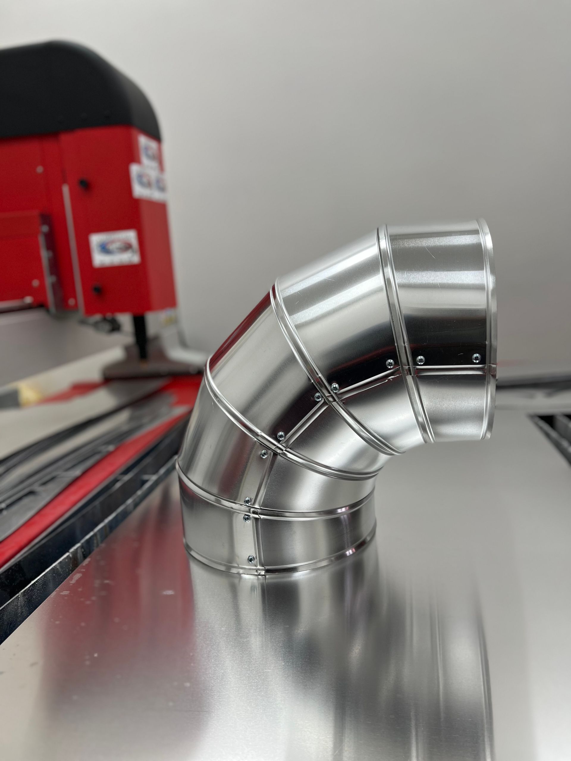 Un primer plano de un codo de metal sobre una mesa.