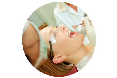 Una mujer se hace examinar los dientes por un dentista.