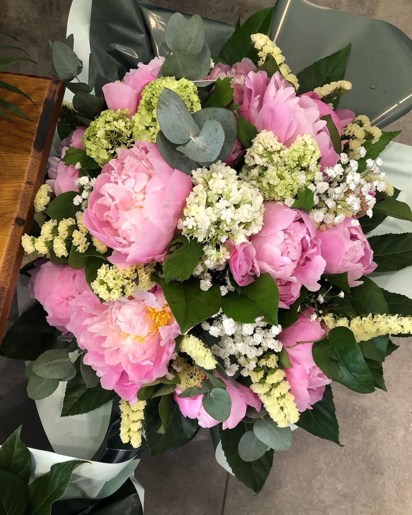 Bouquet de pivoines roses avec des fleurs blanches de remplissage et de la verdure.
