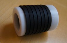 Auf einem Holztisch liegt ein schwarz-weißes Gummiband.
