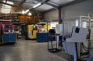 Ein Mann arbeitet in einer Fabrik an einer Maschine.