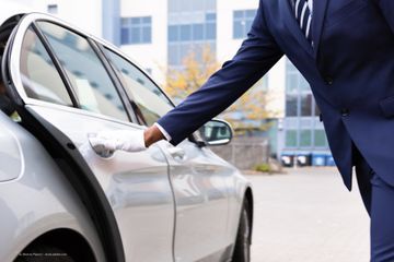 Chauffeur öffnet eine Taxitür