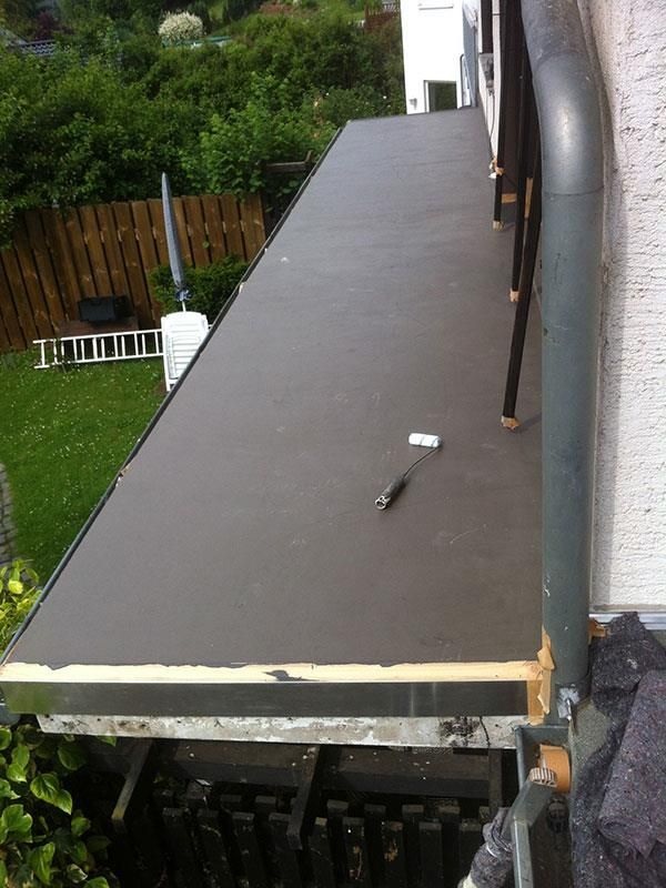 Auf einem Holztisch auf einem Balkon liegt ein Hammer.