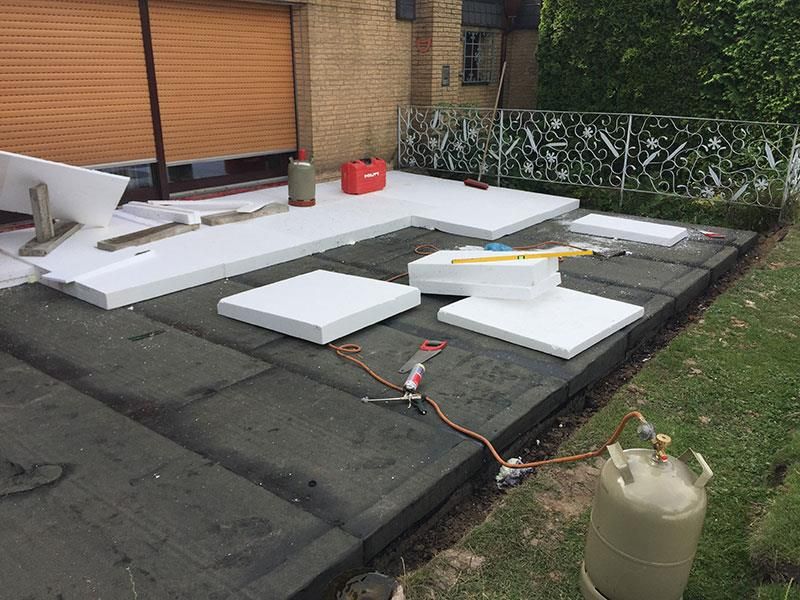 Vor einem Gebäude steht ein Propangastank auf dem Boden.