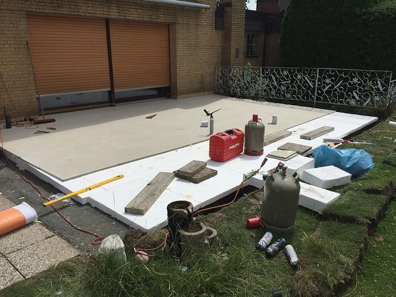 Im Hinterhof eines Hauses wird eine Terrasse gebaut.