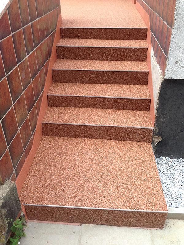 Eine Treppe, die zu einer Backsteinmauer hinaufführt.