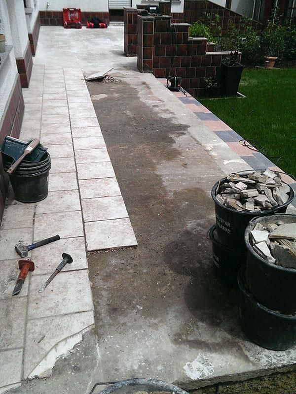 Ein Bürgersteig mit Eimern aus Beton und Werkzeugen darauf