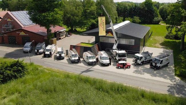 Eine Luftaufnahme eines Gebäudes, vor dem viele Lastwagen geparkt sind.