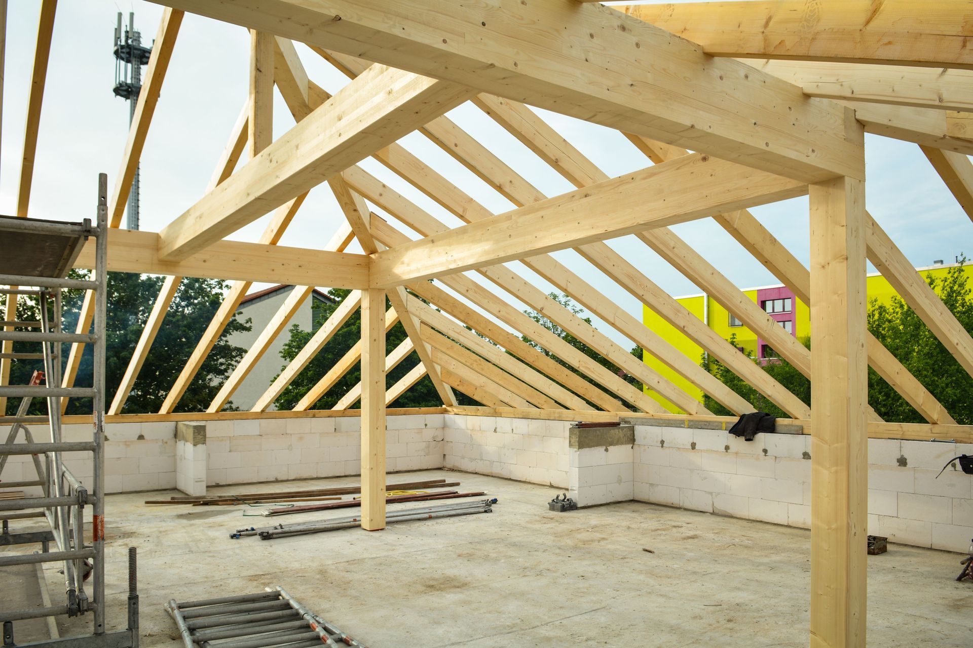 Charpente de toit en bois en cours de construction à l'intérieur d'une structure partiellement édifiée 