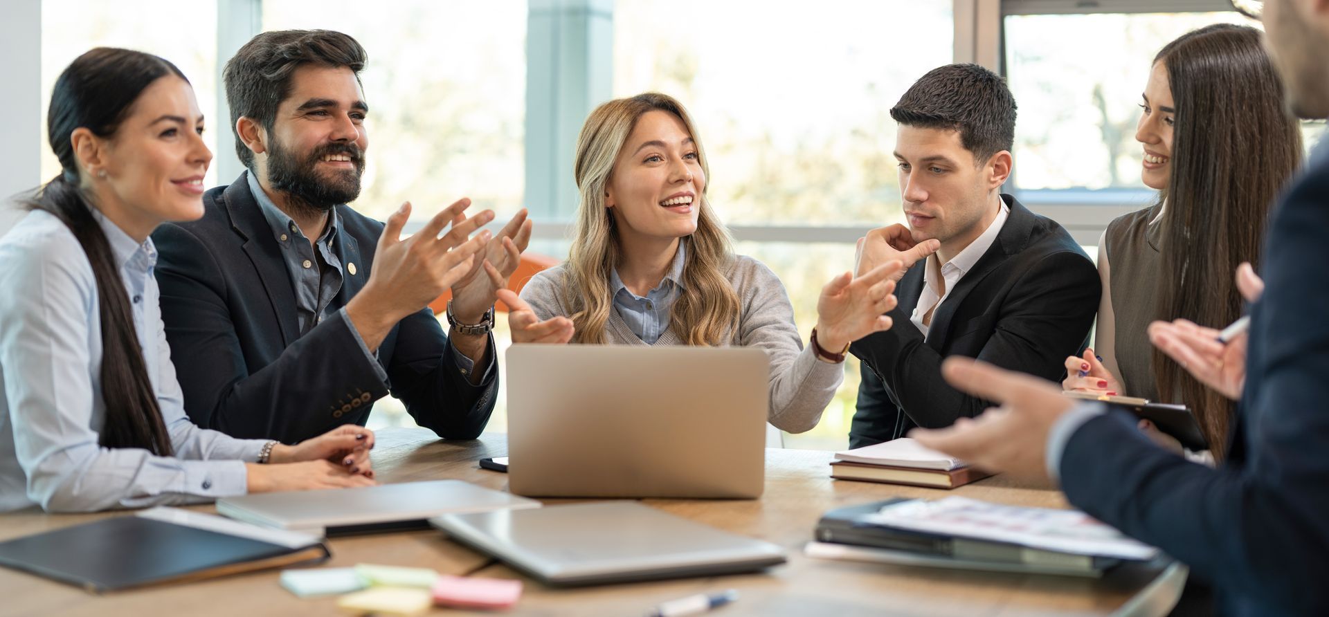 Personnes en réunion assises autour d'une table et discutant