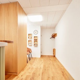 Ein Flur mit Holzboden und einer Uhr an der Wand.