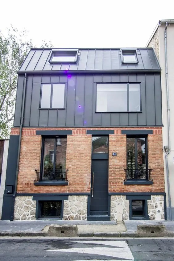 Façade d'une maison avec des menuiseries en aluminium noir neuves, fenêtre, porte d'entrée.
