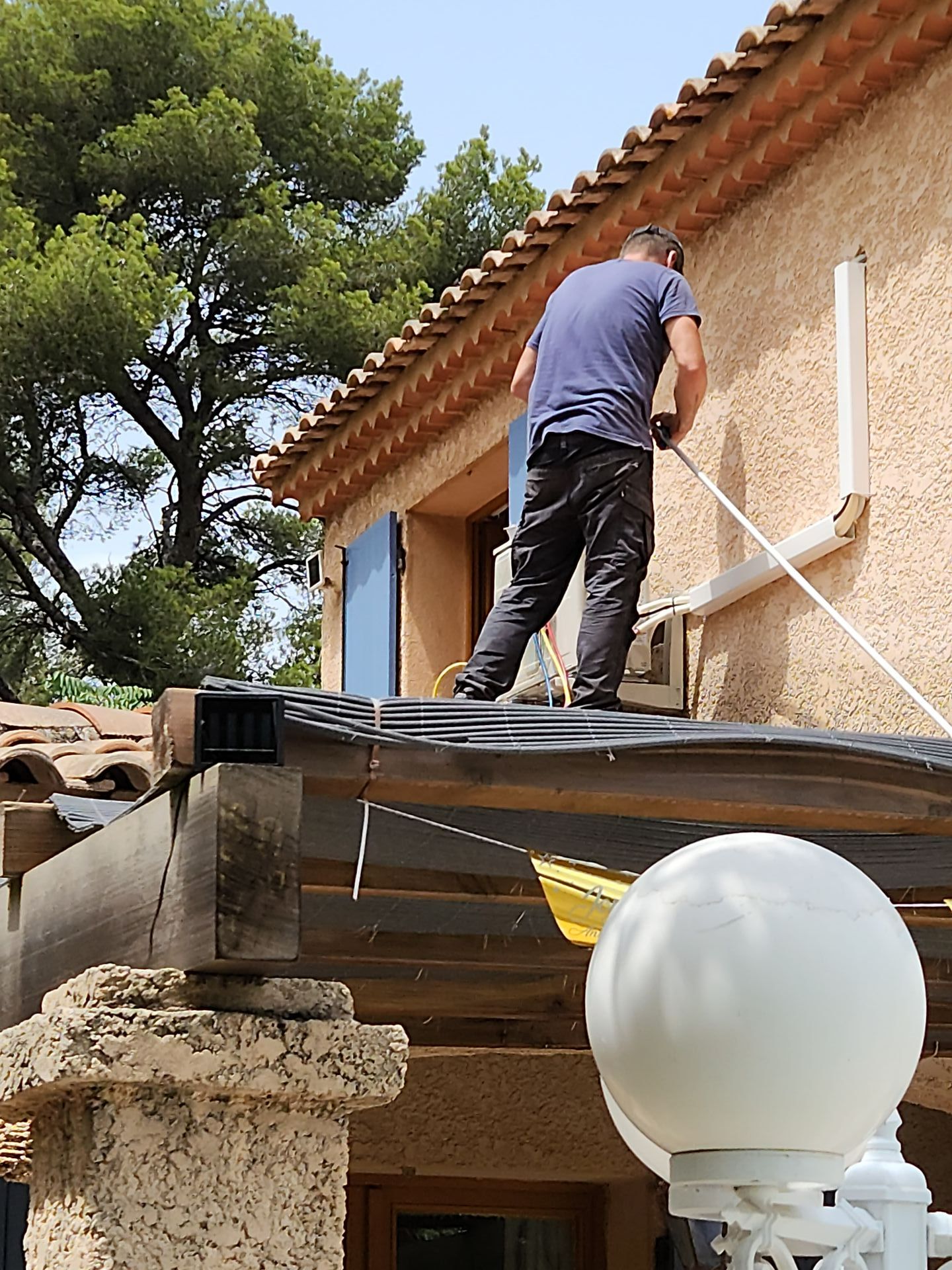 Artisan intervient sur un toit pour rénover une pompe à chaleur