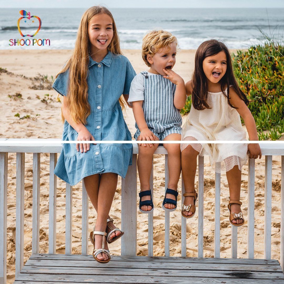 Photo de trois enfants assis sur une rambarde
