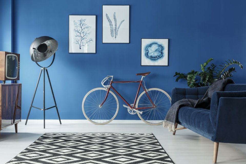 blaue Wand im Haus mit Sofa, Bildern und Fahrrad