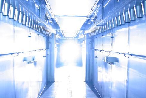 Un largo pasillo con paredes azules y una luz que sale del techo.