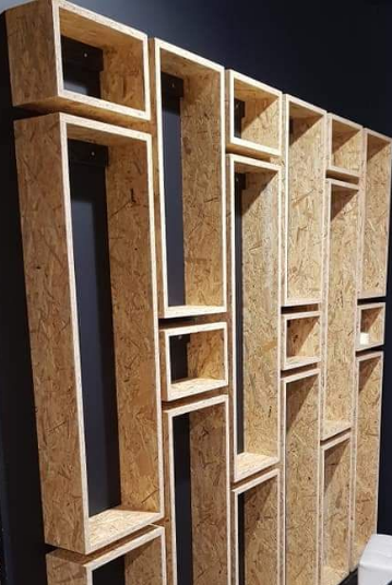 Étagères murales en bois à motif quadrillé. Brun clair avec ouvertures rectangulaires et carrées.