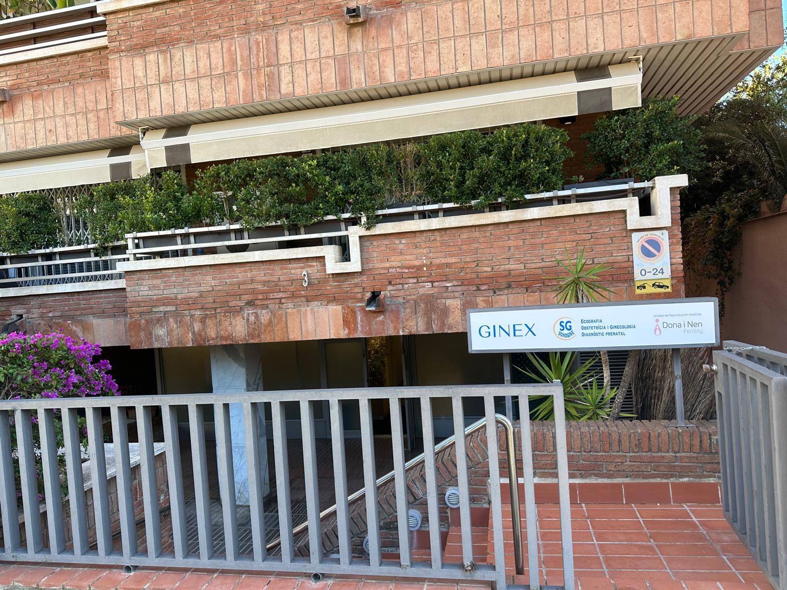 Edificio de ladrillo con el letrero de ONIX sobre una entrada con puerta; se ven vegetación y escaleras.