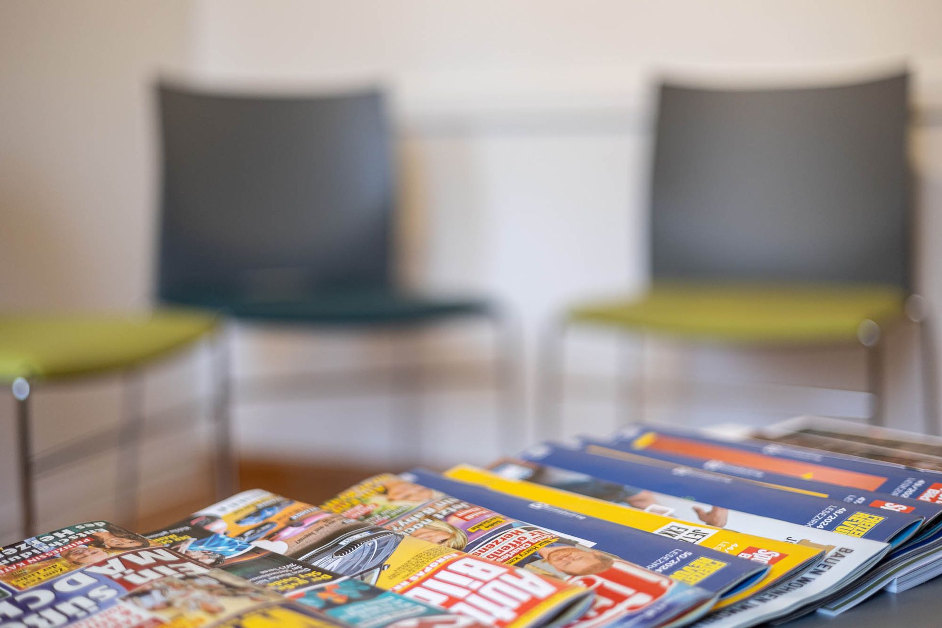 Ein Stapel Zeitschriften liegt auf einem Tisch in einem Wartezimmer.