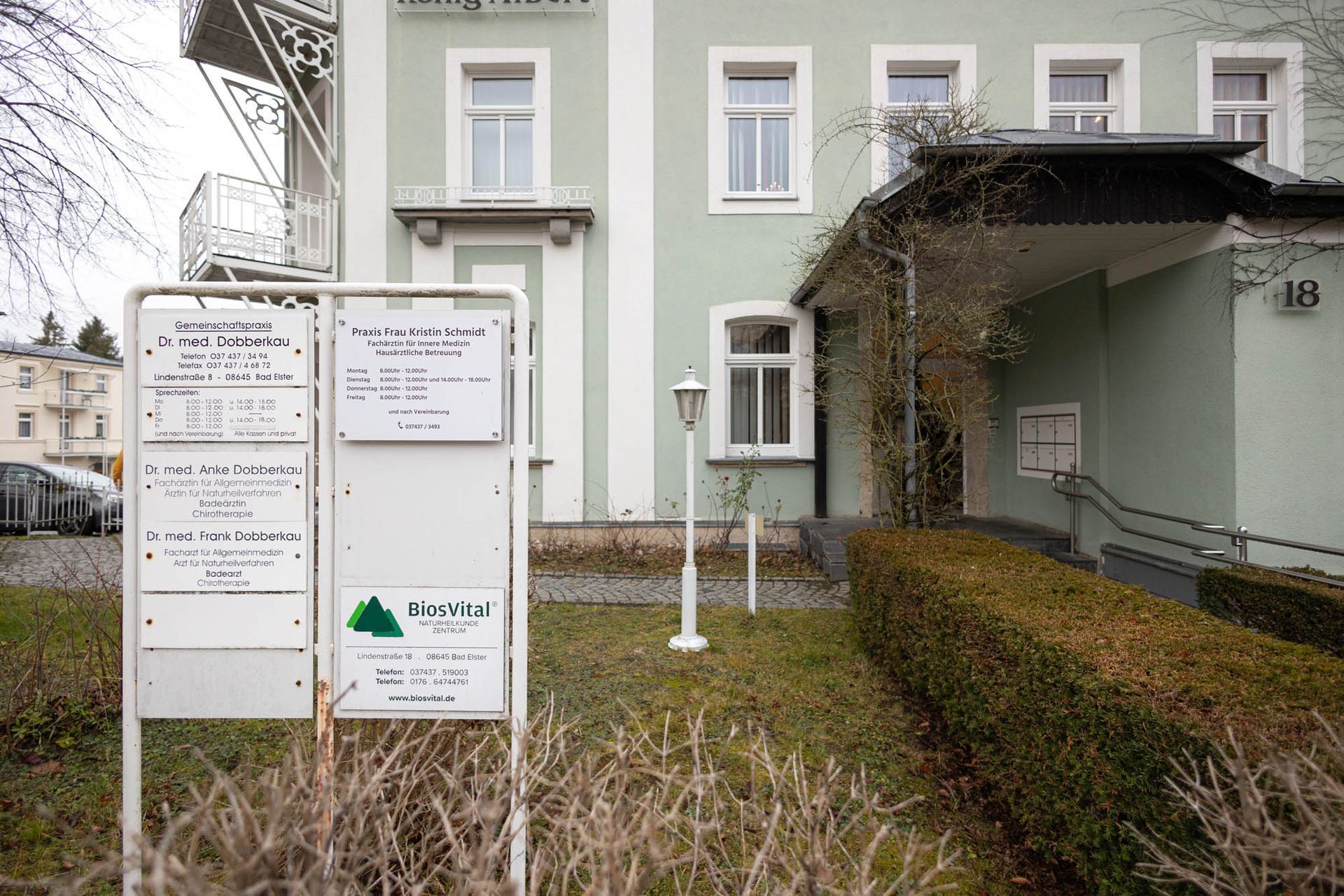 Ein Gebäude mit vielen Fenstern und einem Schild davor.