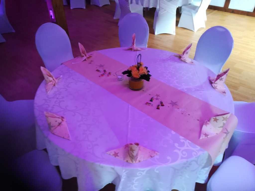 Ein runder Tisch mit einem rosa Tischläufer darauf